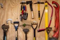Assortment of DIY gardening tools and equipment hanging organised on wooden wall inside garden shed. Royalty Free Stock Photo