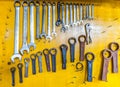 Assortment of do it yourself tools hanging in a yellow wall