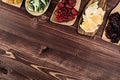 Assortment of dried fruits in spoons on brown wooden background. Royalty Free Stock Photo