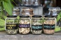 Assortment of dried spices in glass bottles on wooden background. Dry ginger, pandanus, lemon grass and butterfly pea in glass Royalty Free Stock Photo