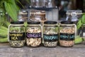 Assortment of dried spices in glass bottles on wooden background. Dry ginger, pandanus, lemon grass and butterfly pea in glass Royalty Free Stock Photo