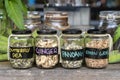 Assortment of dried spices in glass bottles on wooden background. Dry ginger, pandanus, lemon grass and butterfly pea in glass Royalty Free Stock Photo