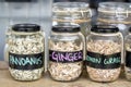 Assortment of dried spices in glass bottles on wooden background. Dry ginger, pandanus, lemon grass in glass jars Royalty Free Stock Photo