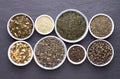 Assortment of dried tea leaves in bowls on dark stone background Royalty Free Stock Photo