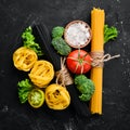 Assortment of dry pasta with ingradients on the old background. Royalty Free Stock Photo