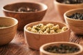 Assortment of dry tea in white bowls on wooden surface