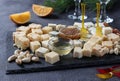 Assortment of elite cheeses on a slate board on a dark background. Snacks for a wine party