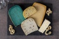 Assortment of elite cheeses on a slate plate on brown background. Snacks for a wine party