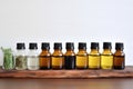 assortment of essential oils on wooden shelf against wall