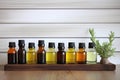 assortment of essential oils on wooden shelf against wall