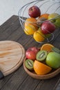 Assortment of exotic fruits close-up: kiwi, red and green apple, oranges and lemon on wooden table. Royalty Free Stock Photo