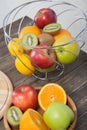 Assortment of exotic fruits close-up: kiwi, red and green apple, oranges and lemon on wooden table. Royalty Free Stock Photo