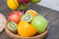 Assortment of exotic fruits close-up: kiwi, red and green apple, oranges and lemon on wooden table. Royalty Free Stock Photo