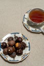 Assortment of fine filled chocolate bonbons on a plate with a cup of red tea Royalty Free Stock Photo