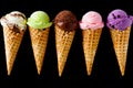 Assortment of five colorful ice cream cones on black background Royalty Free Stock Photo