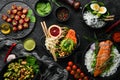 Assortment of food on black stone background. Buddha bowl. Top view.