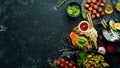 Assortment of food on black stone background. Buddha bowl. Top view.