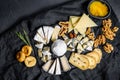 Assortment of French cheese with honey,  nuts and figs on cutting board. Black background. Top view Royalty Free Stock Photo