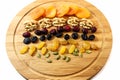 Assortment of fresh delicious dried fruits for a snack on a wooden board - dried apricots, raisins, cranberries, nuts. Royalty Free Stock Photo