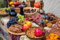 Assortment of fresh fruits and nuts arranged on a table in a variety of containers.