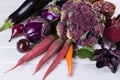 Assortment of fresh raw purple homegrown vegetables on dark wooden table. Royalty Free Stock Photo