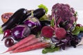 Assortment of fresh raw purple homegrown vegetables on white table. Royalty Free Stock Photo