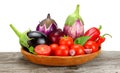 Assortment of fresh raw vegetables on old wooden table with white background. Tomato, eggplant, onion, chili pepper.