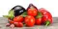 Assortment of fresh raw vegetables on old wooden table with white background. Tomato, eggplant, onion, chili pepper.