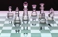 Assortment of glass chess pieces on board with pink and green sh Royalty Free Stock Photo