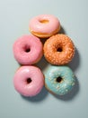 An assortment of glazed donuts of various colors and sizes are neatly arranged on a blue background