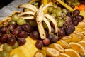 Assortment of grapes and sliced tropical fruits on big plate Royalty Free Stock Photo