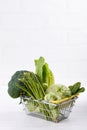 Assortment green vegetables on white table. Broccoli, cauliflower, brussels sprouts, kohlrabi, avocado, asparagus, spinach,