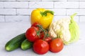 Assortment of healthy food, fresh green red yellow organic vegetables. cucumber, bell pepper, tomatoes, cauliflower on gray Royalty Free Stock Photo