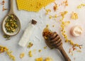 homemade body care products and flowers with wooden spoon on white surface