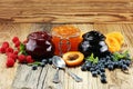 Assortment of jams, seasonal berries, apricot, mint and fruits.