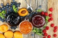 Assortment of jams, seasonal berries, apricot, mint and fruits. Royalty Free Stock Photo