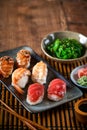 Assortment of Japanese sushi set, nigiri, Gyozas dumplings and wakame salad in ceramic plates with soy sauce and chopsticks on Royalty Free Stock Photo