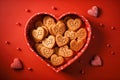 Assortment of love cookies in a heart-shaped box on a red background