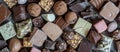 An assortment of luxurious chocolates with various fillings and toppings, featuring dark, milk, and white varieties