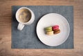 assortment of macaroons with different colors accompanied with a nice coffee in mug at a french bistro