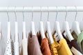 Assortment of many cotton clothes hanging in row on white coat hangers. Royalty Free Stock Photo