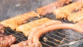 Assortment of marinated meat grilling over the hot coals on a BBQ with sausage, steak. Royalty Free Stock Photo