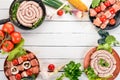 Assortment of meat for barbecue. Sausages, skewers and vegetables. On a wooden background. Royalty Free Stock Photo