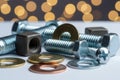 Assortment of metal fasteners and washers on a white surface with a bokeh background Royalty Free Stock Photo