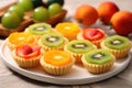 an assortment of mini tarts with kiwi, orange, and apple pieces Royalty Free Stock Photo