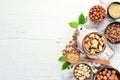 Assortment of nuts in bowls on white wooden background. free space for your text.