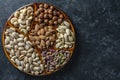 Assortment of nuts in ceramic bowl on a black background, close up, top view, copy space. Cashew, hazelnuts, pistachios and Royalty Free Stock Photo