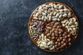 Assortment of nuts in ceramic bowl on a black background, close up, top view, copy space. Cashew, hazelnuts, pistachios and Royalty Free Stock Photo