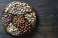 Assortment of nuts in ceramic bowl on a wooden background, close up, top view, copy space. Cashew, hazelnuts, pistachios and Royalty Free Stock Photo