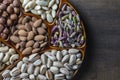 Assortment of nuts in ceramic bowl on a wooden background, close up, top view, copy space. Cashew, hazelnuts, pistachios and Royalty Free Stock Photo